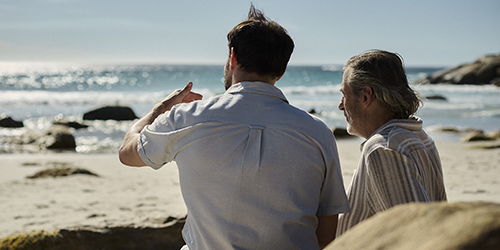 Caregiver con una donna che guarda il mare sorridendo Caregiver con una donna che guarda il mare sorridendo